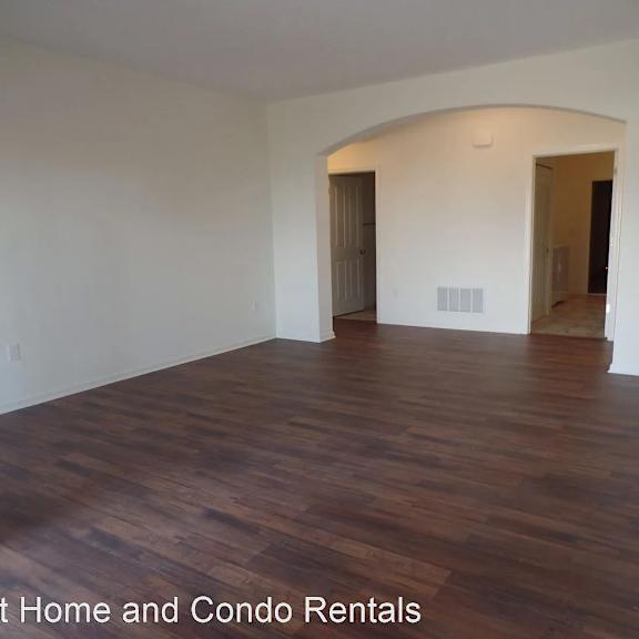 an empty living room with white walls and wooden floors