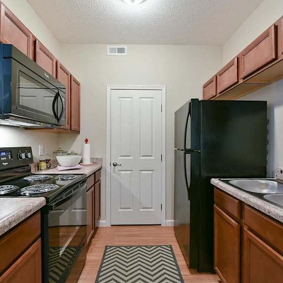 a kitchen with a stove refrigerator and sink