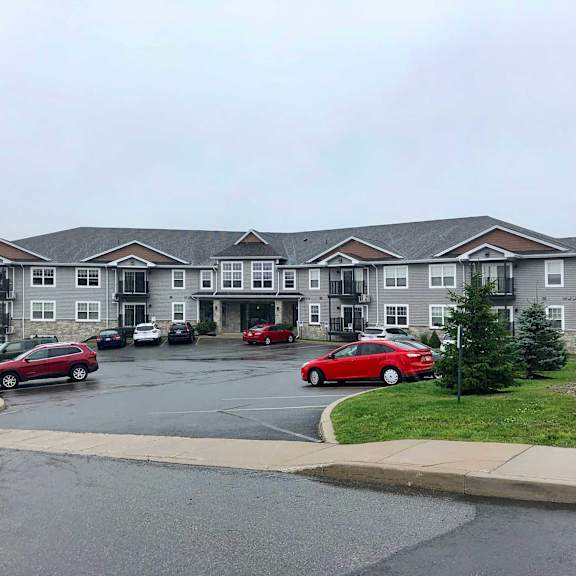 a parking lot in front of a building with cars parked.