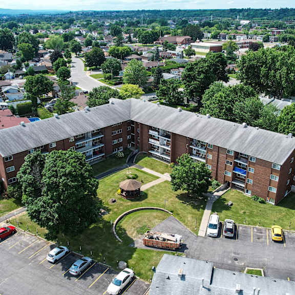 a parking lot with cars and a building in the background.