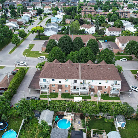 a bird's eye view of a residential area with houses, cars, and a swimming pool.