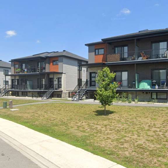 a row of modern townhouses with a street in front.
