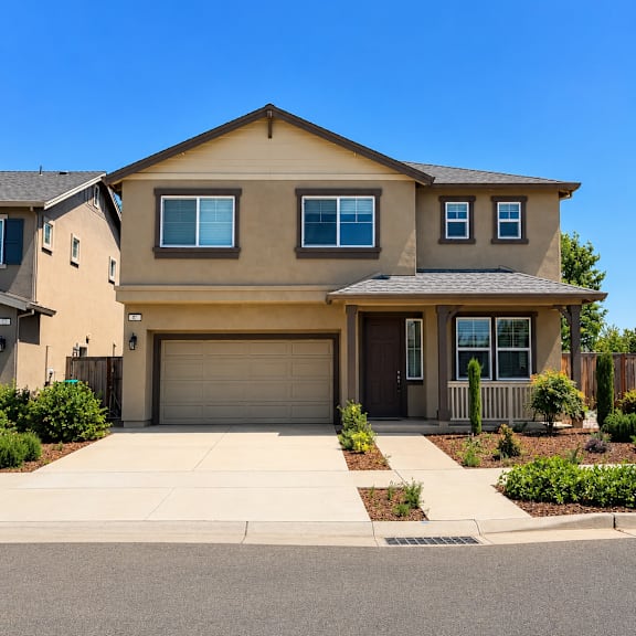 a beige house with a garage door and a driveway.