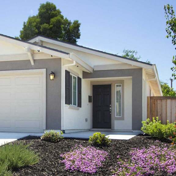 A modern house with a black front door and a white garage door.
