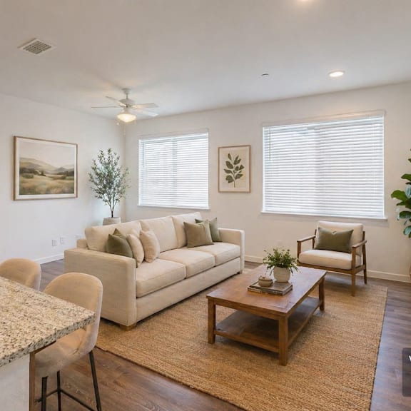 a modern living room with a kitchen area in the background.