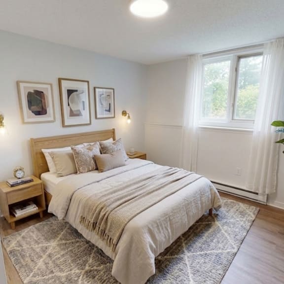 a bedroom with a bed, nightstand, and a plant.