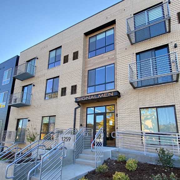 the image shows a modern building with a glass entrance and a sign that reads "signalmen."