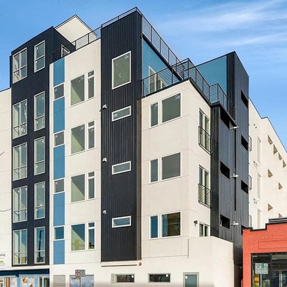 a modern multi-story building with black, white, and blue panels.