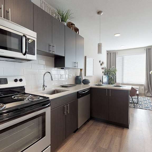 a modern kitchen with a stove, microwave, and oven.