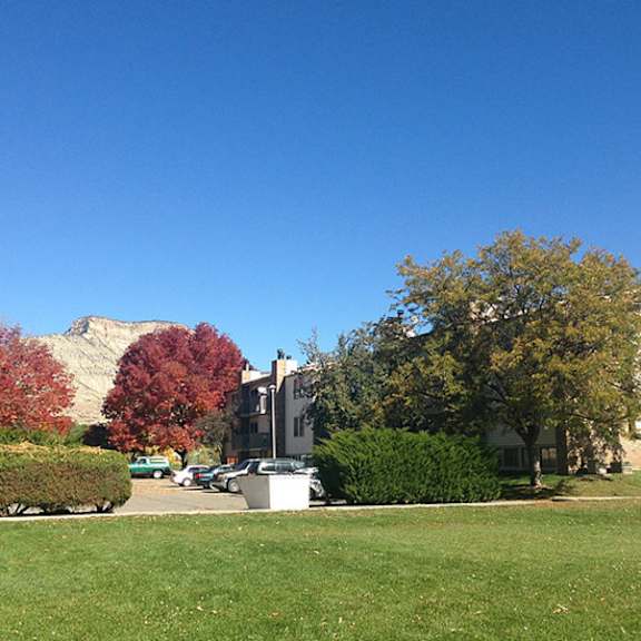 a large building with a green lawn in front of it.