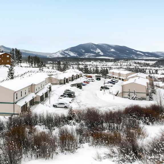 a snowy landscape with buildings and cars.