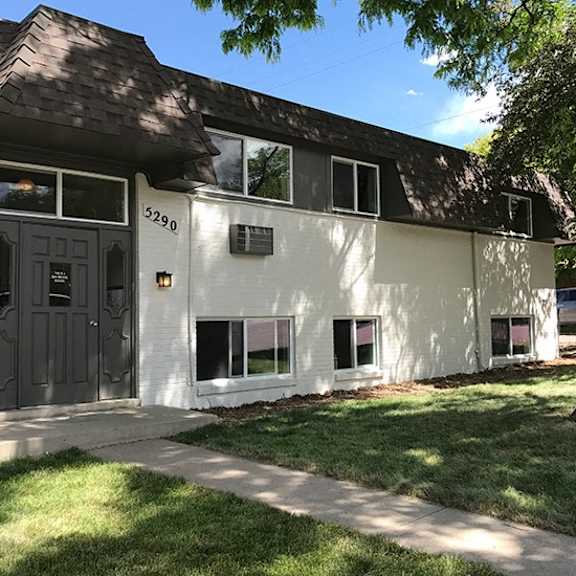 a white building with a black door and windows.