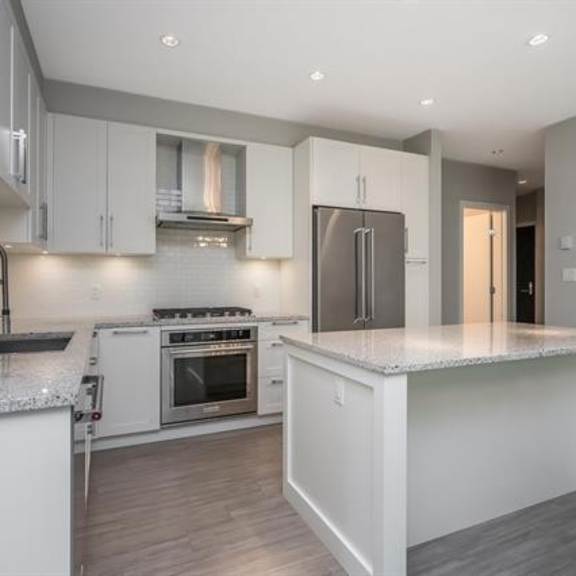 a modern kitchen with white cabinets and a central island.