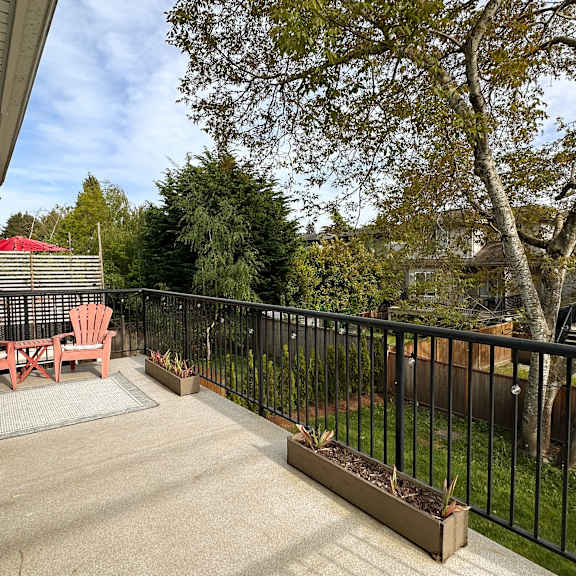 a patio with a table and chairs overlooking a tree.