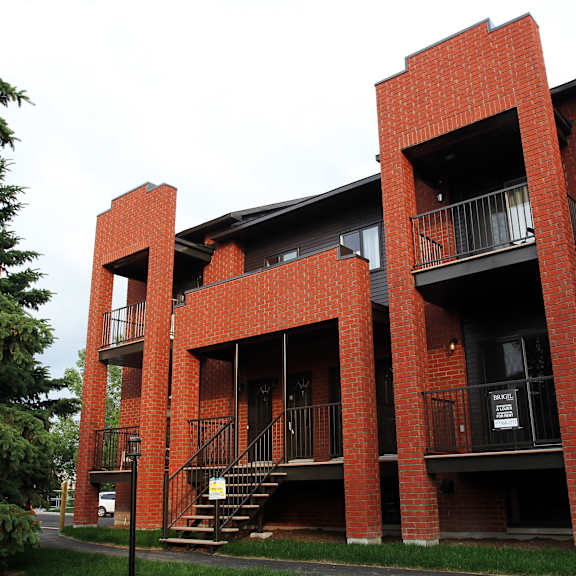 a red brick building with a balcony and stairs.