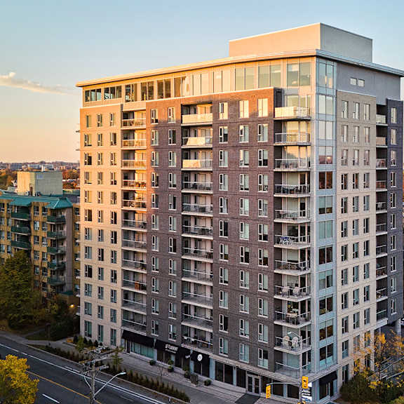 a tall apartment building with many windows and balconies is shown from an aerial perspective.
