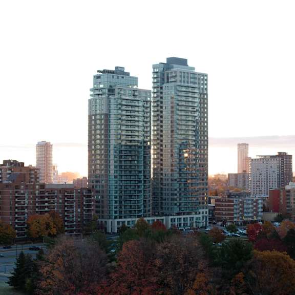 a cityscape with trees in autumnal colors in the foreground at the dale apartments , ottawa, on, k1y 4y5