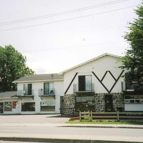 a white building with black trim and a black car parked in front.