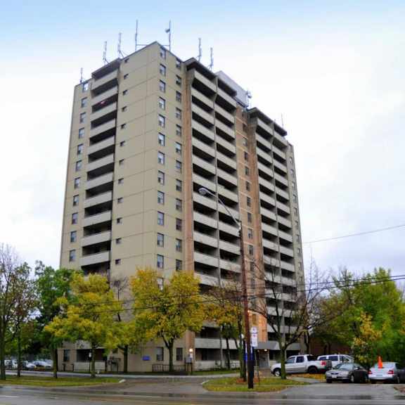 a tall building with a parking lot in front of it.