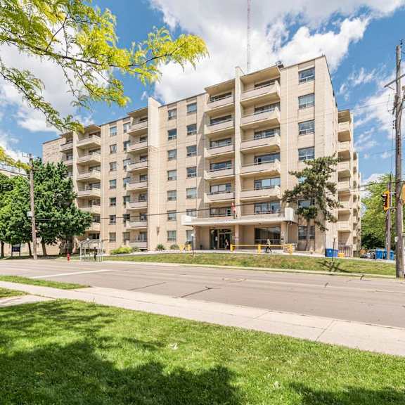 a large apartment building with a grassy area in front.