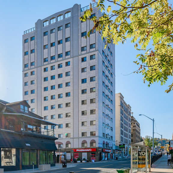 a tall building with many windows stands in the middle of a street.