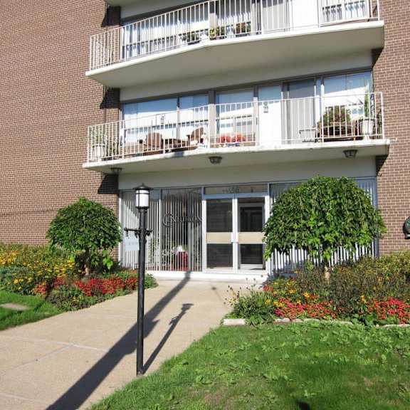 a building with a balcony and a garden in front.
