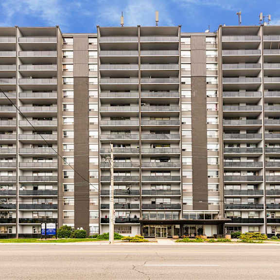 a large, modern apartment building with multiple balconies and a flat roof.