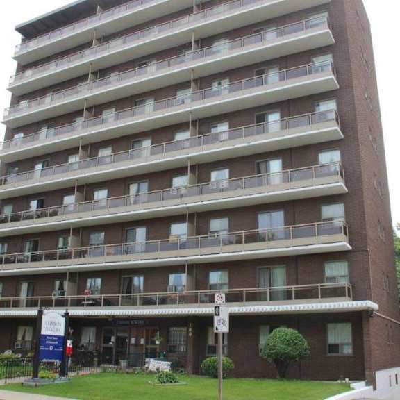 a tall apartment building with a sign in front of it.