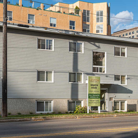 a building with a sign that says "for sale" in front of it.