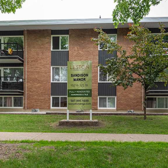 a brick building with a sign that says sandstone manor.