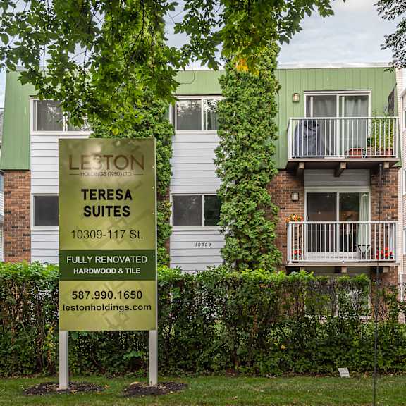 a sign for leston teresa suites is in front of a building.