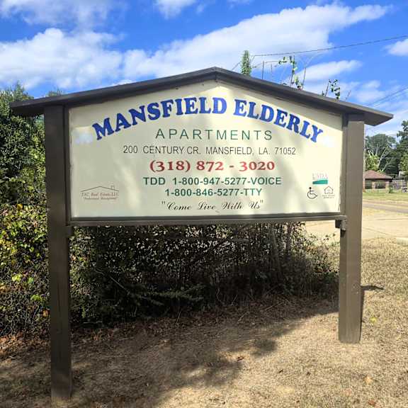 a sign for mansfield elderly apartments with contact information.