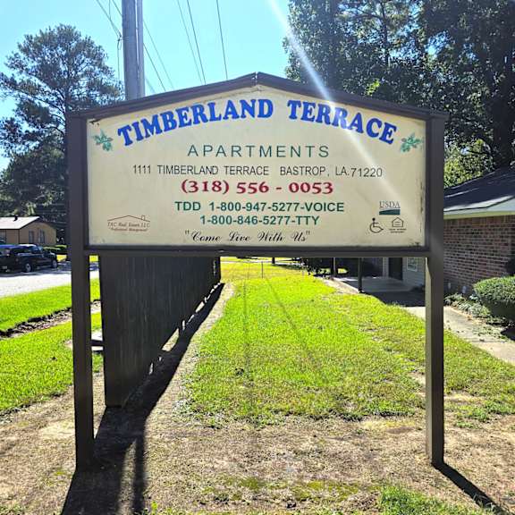 a sign for timberland terrace apartments is displayed in front of a building.