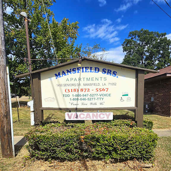 a sign for mansfield senior living apartments is displayed in front of a building.