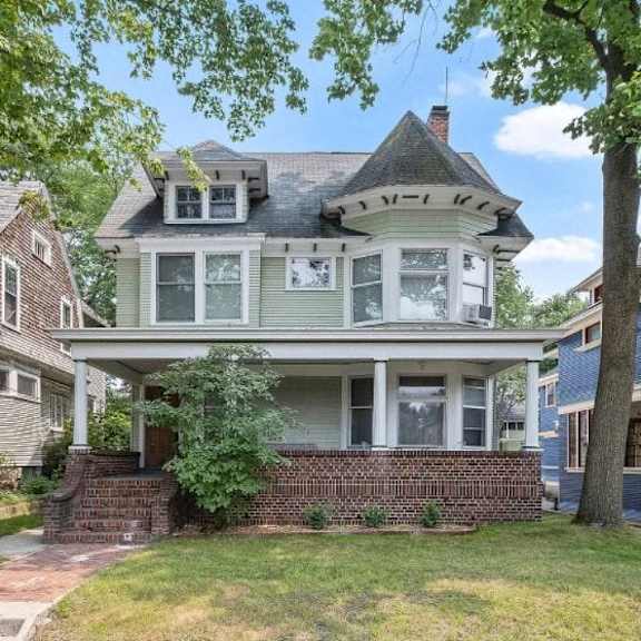 a victorian style house with a grey front porch.