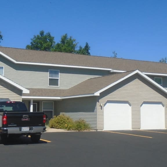 a row of houses with a truck and a car parked in front.