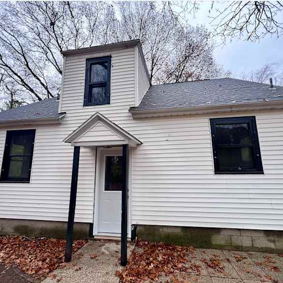 a white house with a black door and windows.