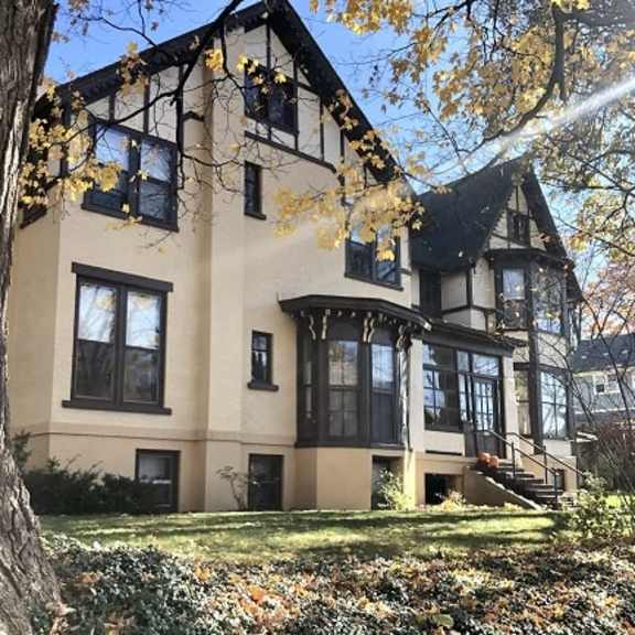 a large house with a tree in front of it.