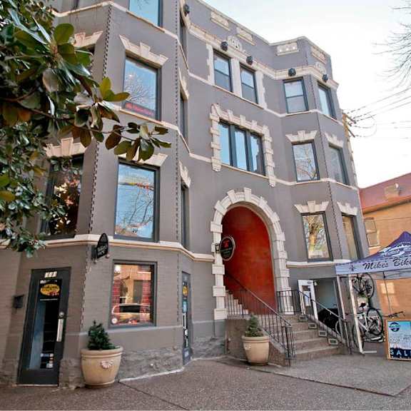 a building with a red door and a sign that says "mile high bikes" in front of it.