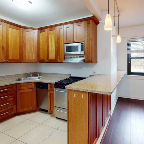 a kitchen with wooden cabinets and a stainless steel refrigerator.