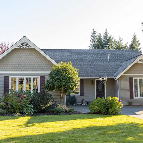 a house with a grey roof and a white window.
