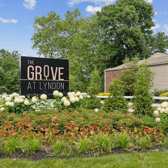 the grove apartments sign in front of flowers and plants at the grove at lyndon, louisville