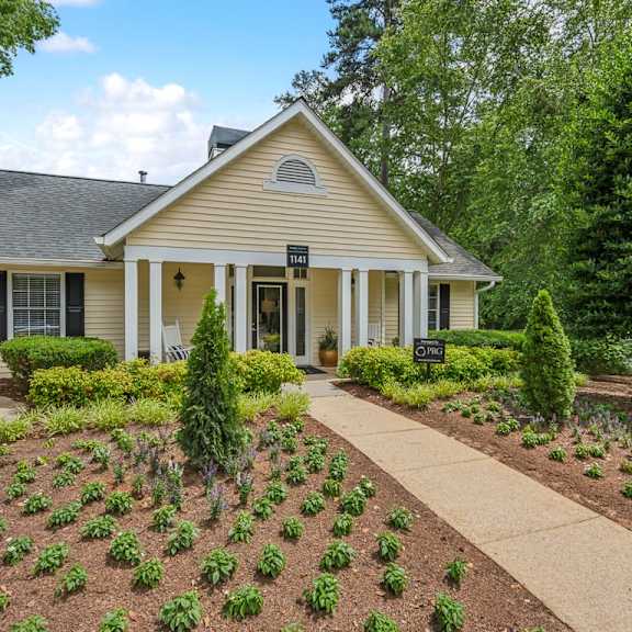 a home with a garden and a sidewalk in front of it at clarion crossing apartments, prg real estate management, raleigh