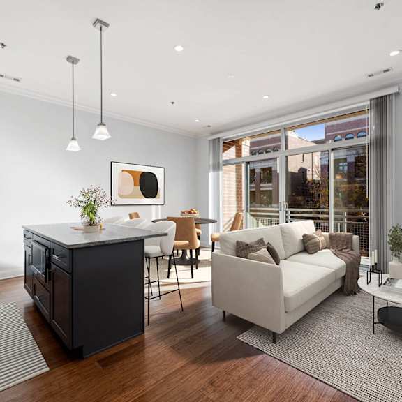A modern living room with a white sofa, a black cabinet, and a coffee table.