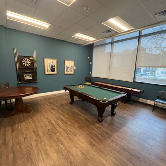 a room with a pool table and a dartboard.