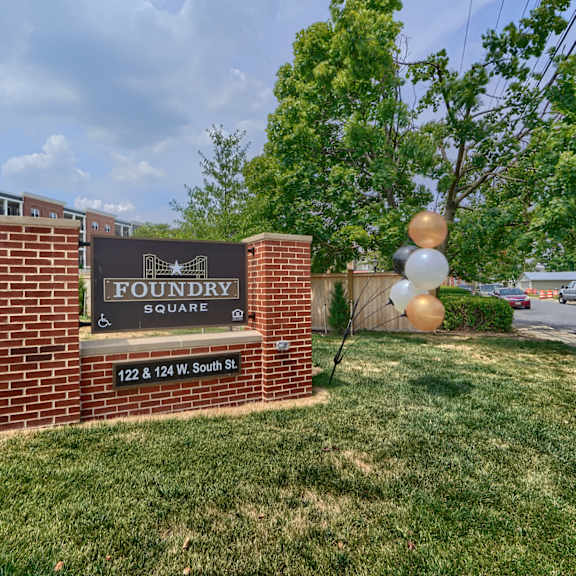a sign for foundry square is in front of a grassy area.