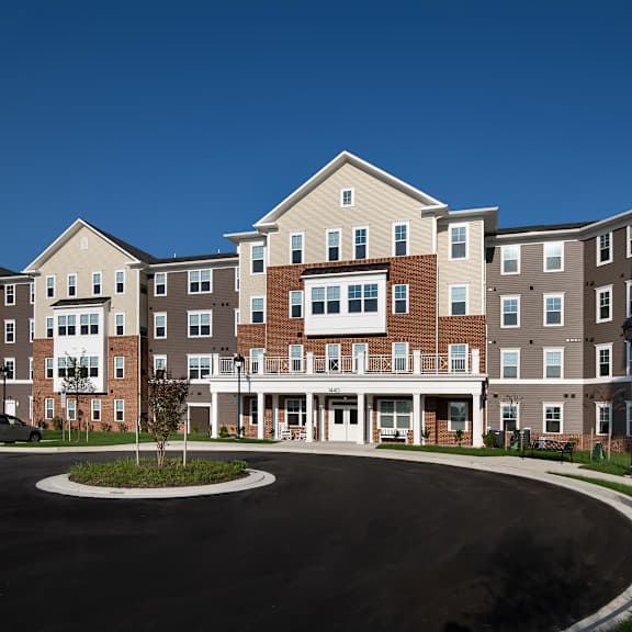 a roundabout in front of an apartment building with a blue sky background