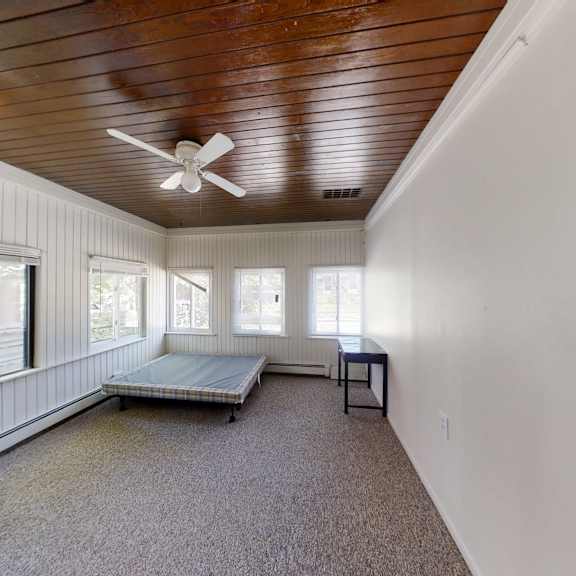 a room with a wooden ceiling and a carpeted floor.