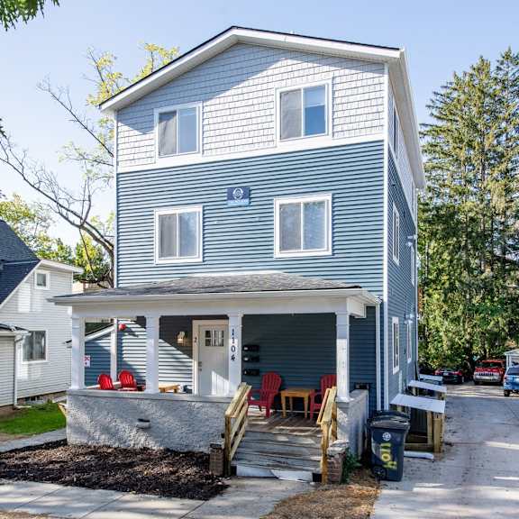 a two-story house with a garage and a covered porch.