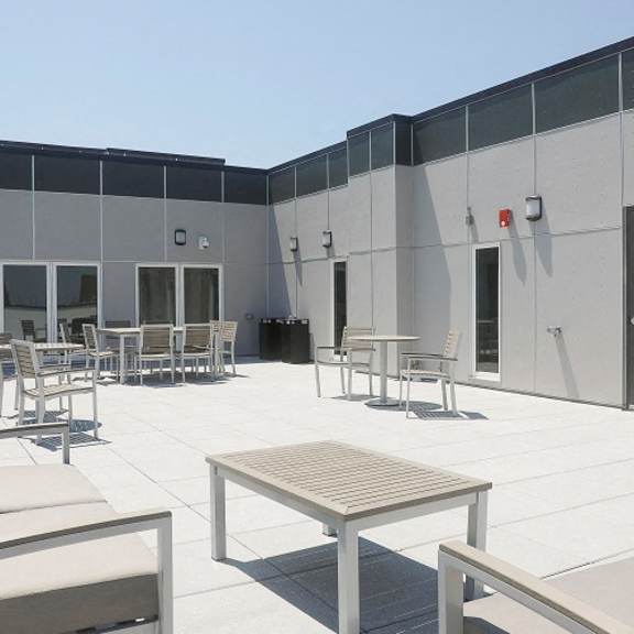 a patio area with tables and chairs in front of a building